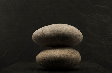 Fototapeta na wymiar zen stones on dark background for product presentation podium background