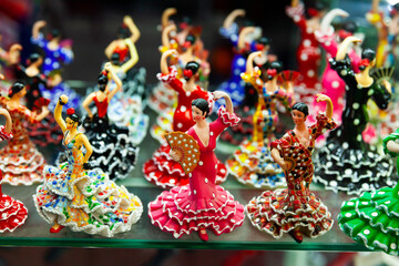 Variety of handcrafted ceramic figurines of Spanish flamenco dancers on shelves of souvenir shop