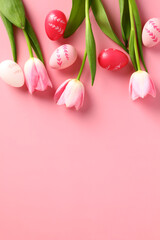 Happy Easter vertical banner template. Flat lay tulips flowers and colorful Easter eggs on pastel pink background.