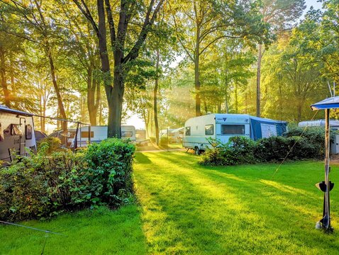 Berlin, 2022: Several caravans on a campsite in the morning sun in summer
