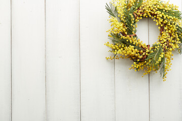 Beautiful wreath of yellow mimosa flowers on white boards