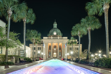 Evening photo of the historic Volusia County Courthouse and fountain pool in DeLand, Florida.