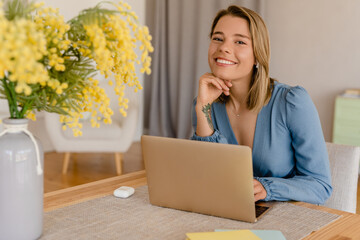 young pretty stylish woman working remote at home at table workplace, student education
