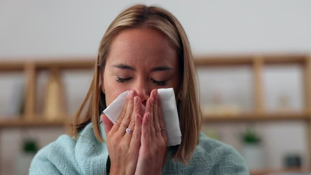 Sick asian woman, blowing nose and home living room with tissue, allergies and nasal pain in sinus. Girl, toilet paper and allergy with flu, healthcare problem or covid in apartment on lounge couch