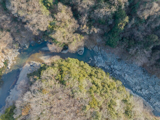 山の間を流れる渓流と差し込む夕日の空撮（ドローン）