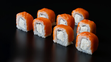 Eight pieces of Philadelphia sushi roll on a black reflective background. Copy space. Selective focus.