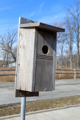 Bluebird birdhouse on metal post on a sunny day