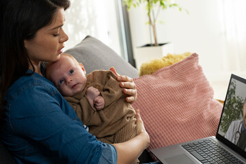 A young new mom is concerned about her baby's health, looking for doctors' advice online. Telemedicine. Оnline counseling with a pediatrician