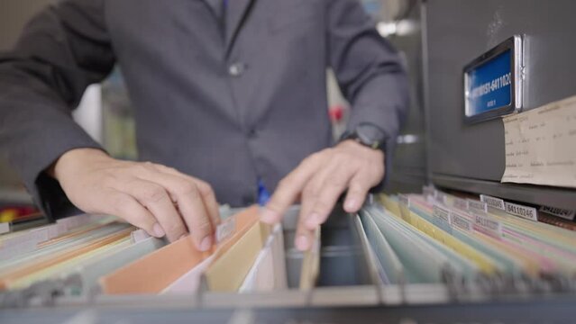 Close up of an officer searching for documents in the office filing cabinet