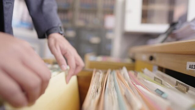 Close up of an officer searching for documents in the office filing cabinet