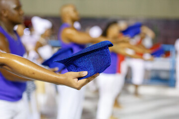 man holding hat during carnival rehearsal in Rio de Janeiro.