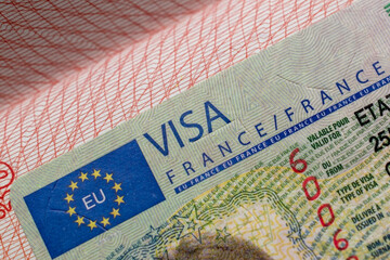 French visa stamp in a travel passport, France Schengen visa, immigrant, work and travel documents, emigration, immigration, tourism concept