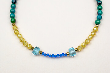 Colorful gemstone crystal beads necklace on white, unique handmade jewelry background
