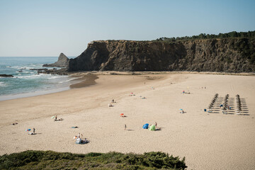 Spiaggia del Portogallo poco affollata con rocce a picco sul mare e onde dell'oceano Atlantico