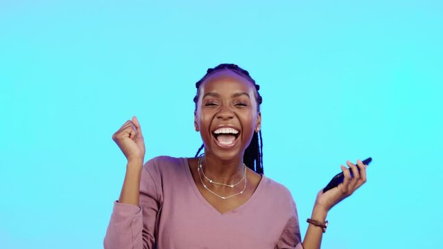 Wow, happy and excited black woman with phone reading email news of bonus, promotion or announcement in studio. Winning, prize notification and African girl celebrating with smile on blue background