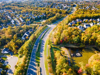 View of a small town with low-rise houses in Virginia USA. Drone view of the autumn landscape with a road.