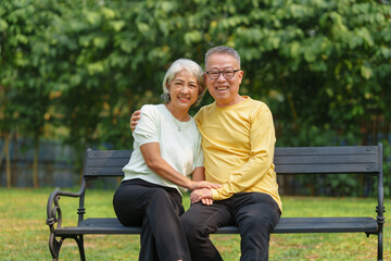 Fototapeta premium Never stop loving each other, Asian people elderly husband and wife relaxing in park outdoor in springtime.