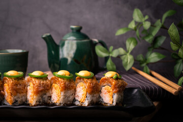 tempura sushi roll topped with seared salmon and serve with hot tea. Japanese traditional dishes and healthy food. homed cooking