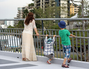 Woman and two boys enjoy a city view from the bridge