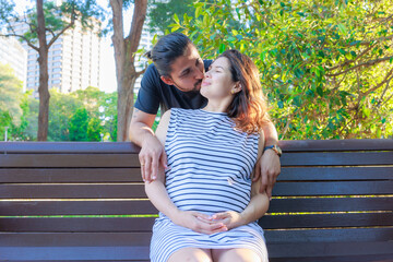 妊娠した女性を抱きしめ、お互いに見つめ合うカップル