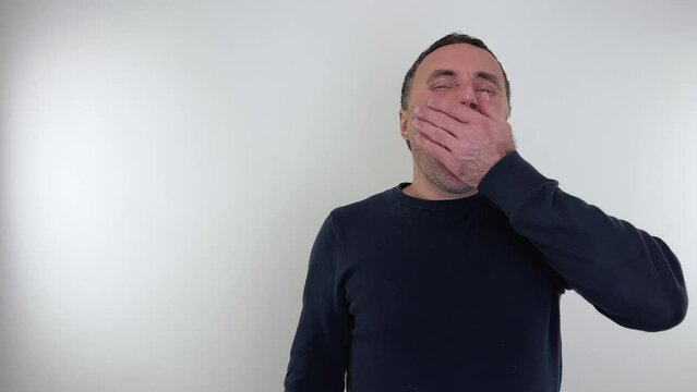 Emotions of a man man yawns he closed his eyes tightly and opened his mouth Hairy hands lie on his cheeks 