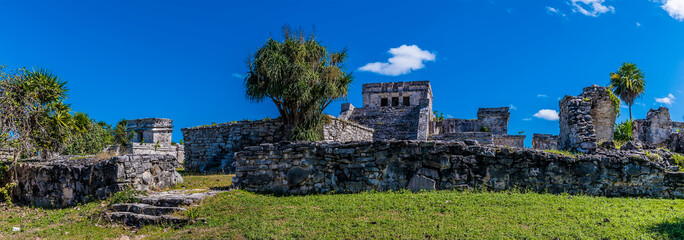 Fototapeta na wymiar A panorama view towards the oratory and central ruins at the Mayan settlement of Tulum, Mexico on a sunny day