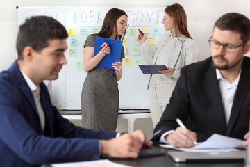 Female colleagues working on business plan in office