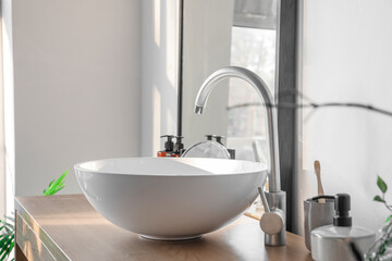 White sink on table in light bathroom, closeup