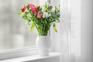 Vase with beautiful alstroemeria flowers on windowsill
