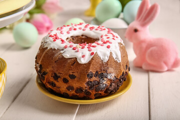 Plate with tasty Easter cake on light wooden table