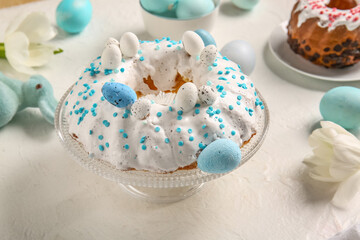 Dessert stand with tasty Easter cake on light background