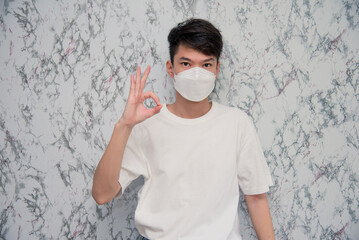 Handsome man showing okay gesture isolated on White background,protecting from virus during quarantine. Covid-19