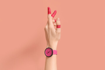 Woman with painted fingers and stylish wristwatch on pink background