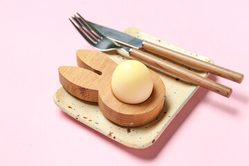 Table setting with Easter egg on pink background, closeup
