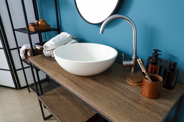 Sink with bath accessories on table in bathroom