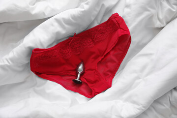 Panties with anal plug on white blanket