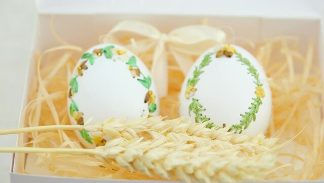 eggs embroidery with ribbons on eggshells three spikelets of wheat appear in front of them blur sharpness moves to fore Easter art needlework handmade technology agriculture goose Ostrich eggs