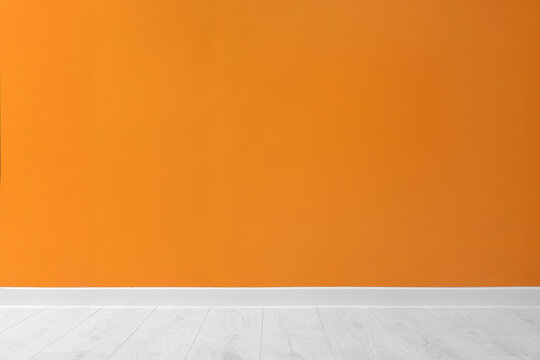 Beautiful orange wall and wooden floor in clean empty room