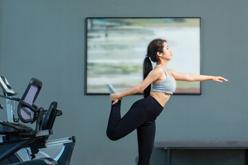 Obraz premium Close up of beautiful young asian girl is wearing workout clothes and doing yoga exercises at the fitness center.