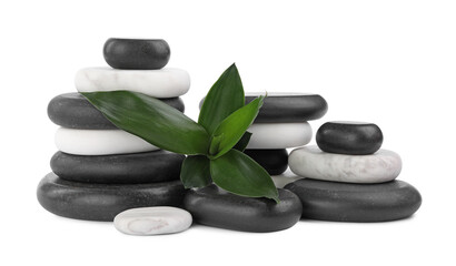 Stacks of spa stones and bamboo leaves on white background