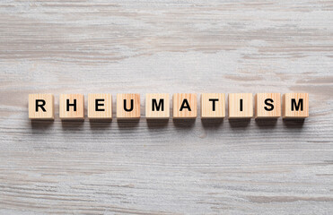 Word Rheumatism made of cubes on wooden table, top view