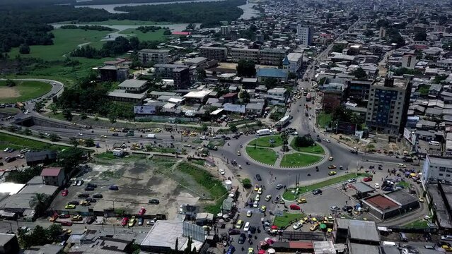 Aerial view of Rond-Point Deido roundabout, towards a industrial area in Douala city, Cameroon - pan, drone shot