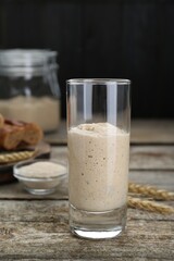 Glass with fresh sourdough on wooden table