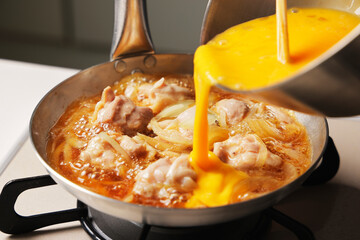 溶き卵を入れた親子丼の調理シーン