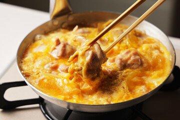 溶き卵を入れた親子丼の調理シーン