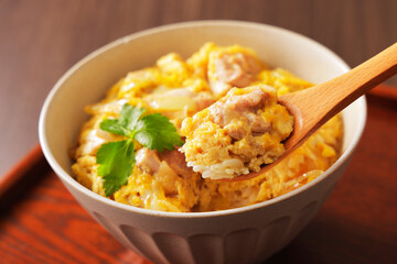 木のスプーンで持ち上げた美味しそうな親子丼