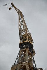 Fototapeta na wymiar Powerful crane at construction site against grey sky