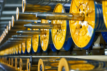 Yellow bobbins and metal spools in production workshop