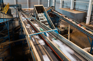 Conveyors carry trash and empty platforms at recycling plant