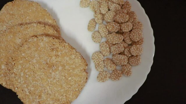 indian traditional sweet tilkut in white plate with black background